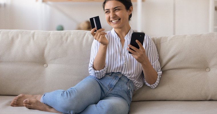 woman smiling while using credit/debit card