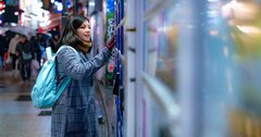 Young woman smiling while using a vending machine at night
