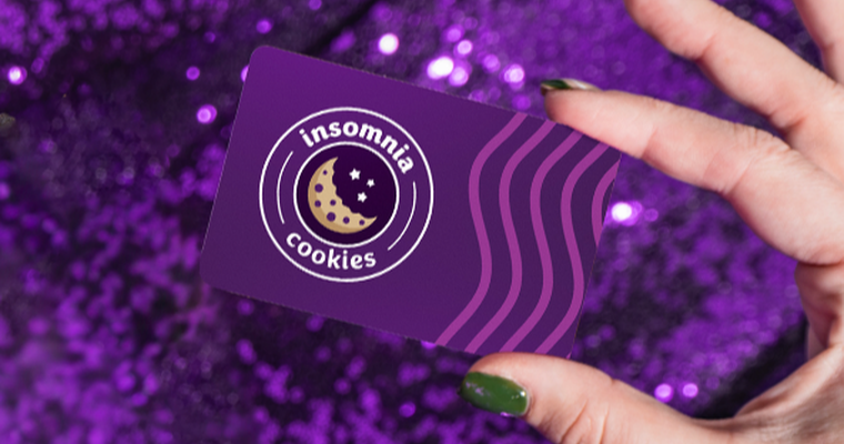 photo of a hand holding a card with Insomnia logo on it